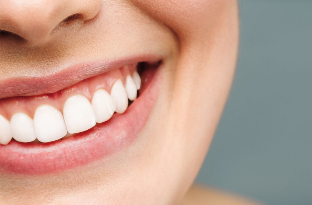 A close-up shot of a woman's radiant smile revealing her healthy teeth.